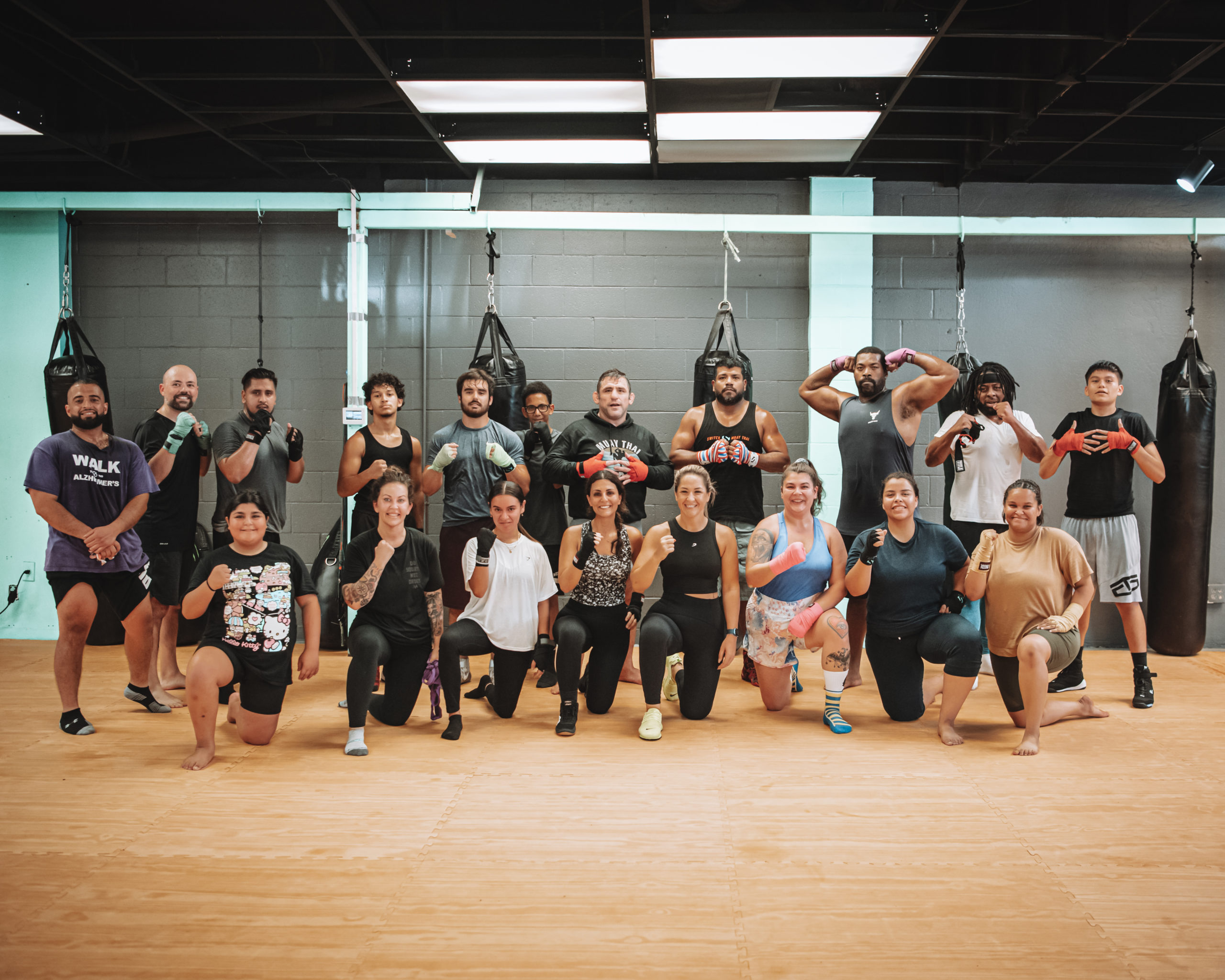 The Switch Fitness San Diego team posed together on the mat in front of the heavy bags.