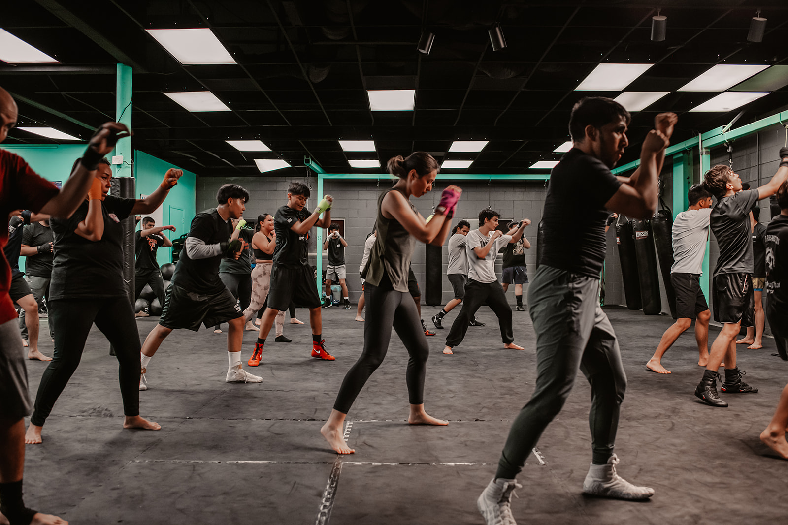 A Muay Thai class throwing strikes in the training room at Switch Fitness San Diego.